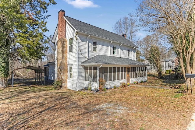 340 W Peachtree, Woodruff, SC 29388 - view of front of home featuring roof with shingles, a chimney, a front yard, a sunroom, and a carport