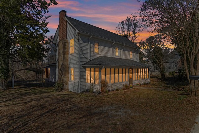340 W Peachtree, Woodruff, SC 29388 - view of front of house with a shingled roof, a sunroom, a detached carport, a chimney, and a front yard