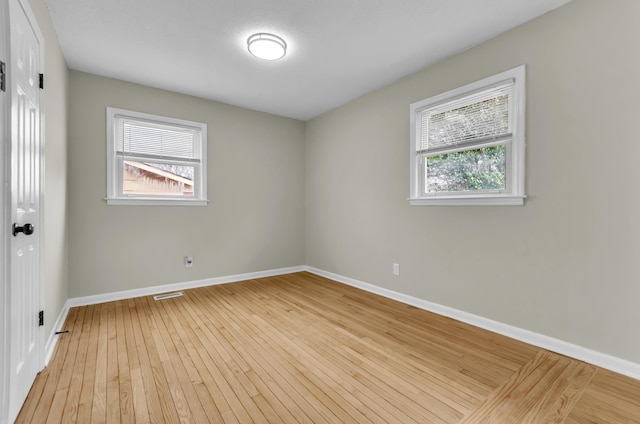 spare room featuring light wood finished floors and baseboards