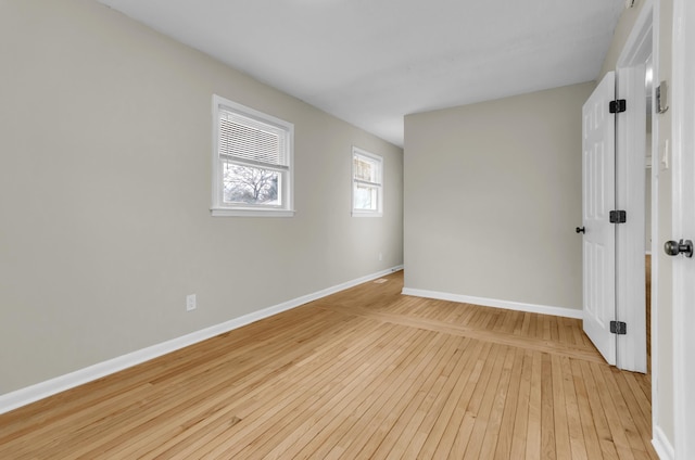 empty room with light wood finished floors and baseboards