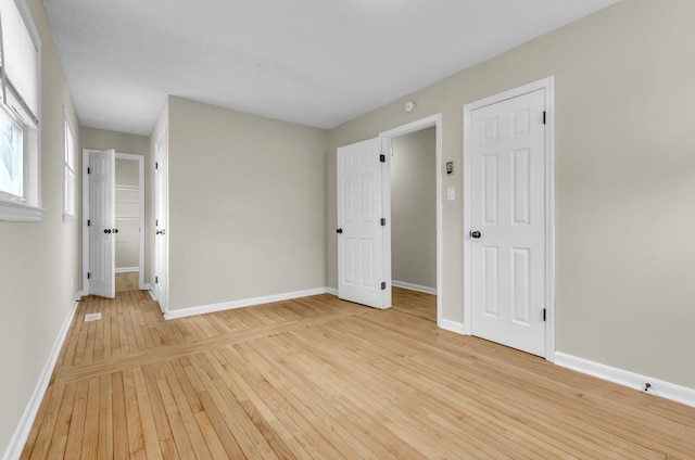 spare room featuring light wood-type flooring and baseboards