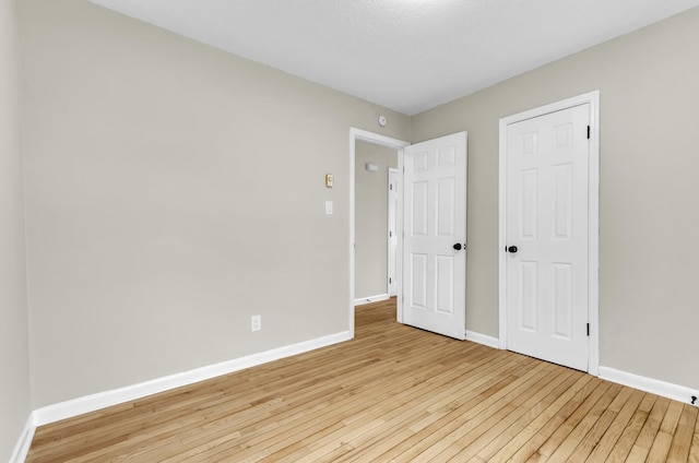 unfurnished bedroom with light wood-style flooring and baseboards