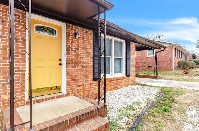 view of exterior entry featuring brick siding