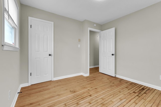 unfurnished bedroom featuring light wood-type flooring and baseboards