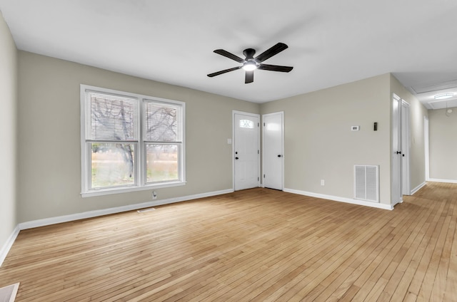 unfurnished room with attic access, visible vents, light wood-style floors, and baseboards