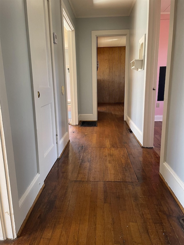 hall with ornamental molding, dark wood-style flooring, and baseboards