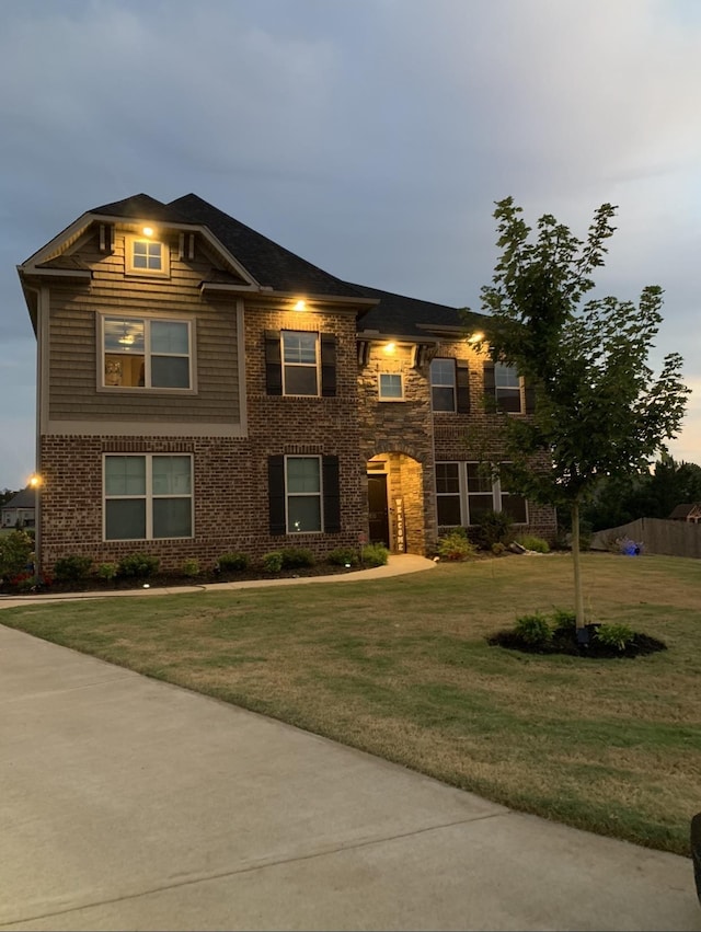 view of front of house featuring a front yard and brick siding