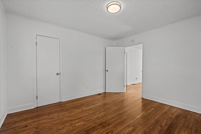 unfurnished bedroom with crown molding, baseboards, and wood finished floors