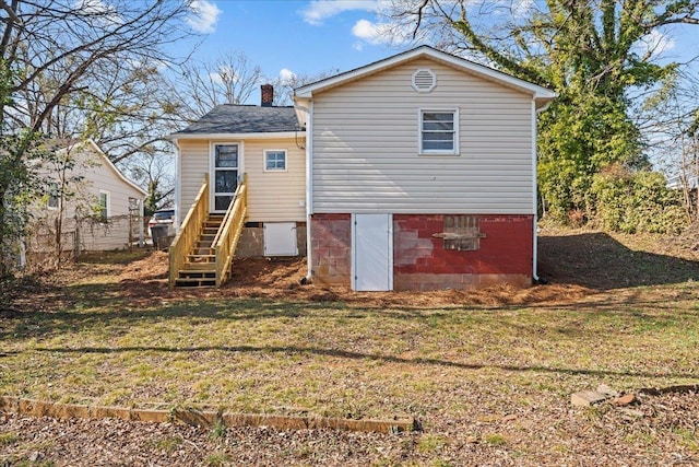 rear view of property featuring fence, a yard, and a chimney