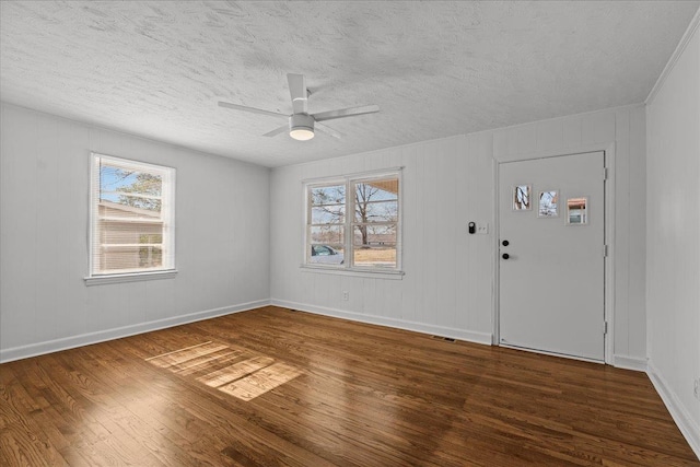foyer entrance with a textured ceiling, wood finished floors, baseboards, and a ceiling fan