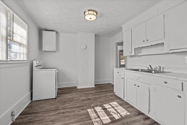 kitchen featuring light countertops, a sink, white cabinetry, washer / clothes dryer, and dark wood-style flooring