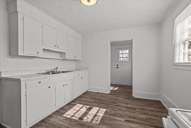 kitchen featuring light countertops, range, dark wood finished floors, a sink, and white cabinets