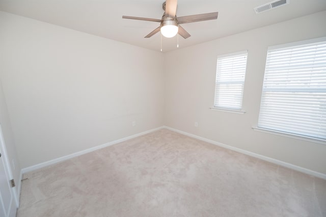 empty room featuring light carpet, baseboards, visible vents, and ceiling fan