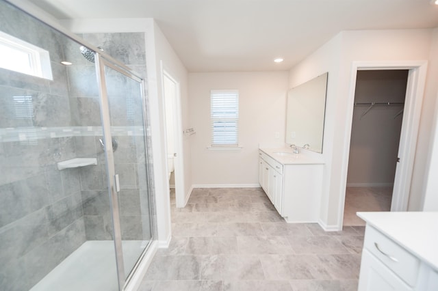 full bathroom featuring toilet, a stall shower, baseboards, and vanity