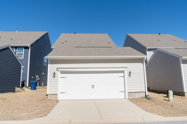 view of front of home featuring a garage, roof with shingles, and driveway