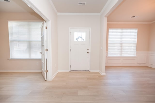 entryway featuring a healthy amount of sunlight, light wood-style floors, visible vents, and crown molding