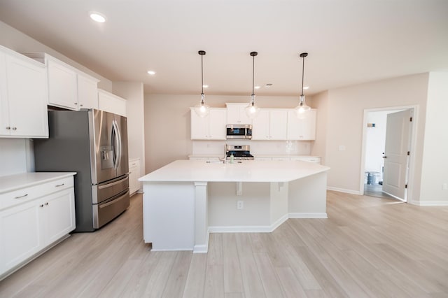 kitchen featuring white cabinetry, light wood-style flooring, a center island with sink, and appliances with stainless steel finishes