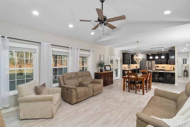 living area with lofted ceiling, light wood-style floors, recessed lighting, and ceiling fan with notable chandelier