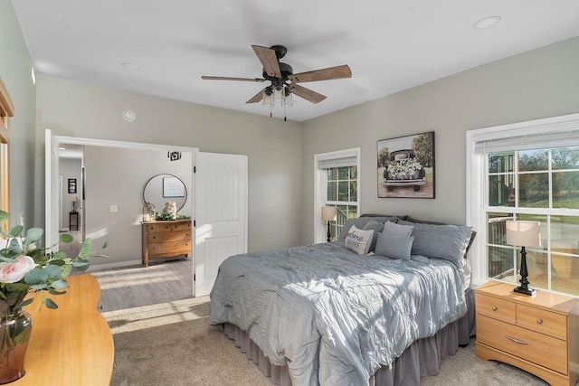 bedroom with light carpet and a ceiling fan