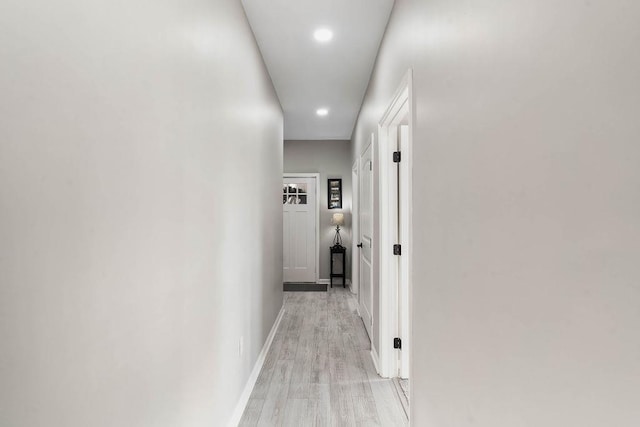 hall featuring light wood-style flooring, baseboards, and recessed lighting