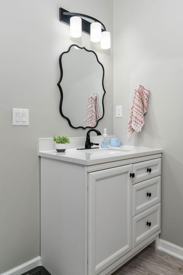 bathroom with vanity, baseboards, and wood finished floors