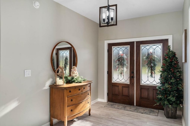 entryway with light wood-style floors, french doors, a healthy amount of sunlight, and baseboards