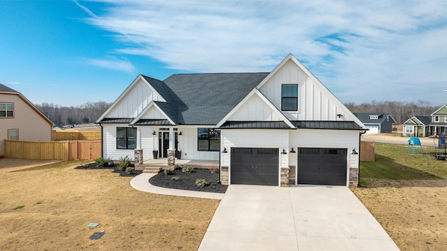 modern inspired farmhouse with concrete driveway, metal roof, a standing seam roof, fence, and board and batten siding