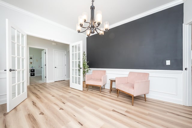 unfurnished room with a wainscoted wall, ornamental molding, wood finished floors, and french doors