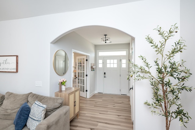 entryway featuring light wood-style floors and arched walkways