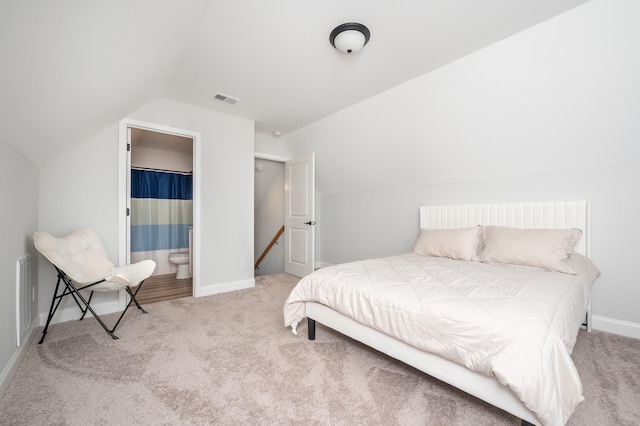 bedroom with vaulted ceiling, carpet, and visible vents