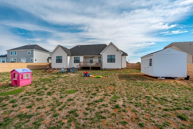 back of house with a fenced backyard, an outdoor structure, a yard, crawl space, and a shed