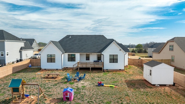 back of house with an outbuilding, crawl space, a fenced backyard, and a storage unit