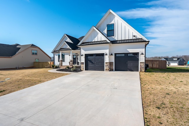 modern farmhouse with board and batten siding, a standing seam roof, an attached garage, and concrete driveway