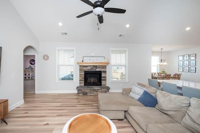 living area with light wood-type flooring, recessed lighting, visible vents, and a stone fireplace