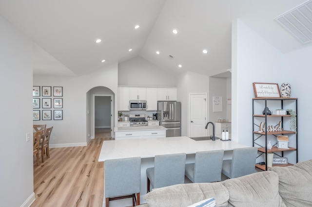 kitchen featuring light countertops, visible vents, appliances with stainless steel finishes, open floor plan, and white cabinets