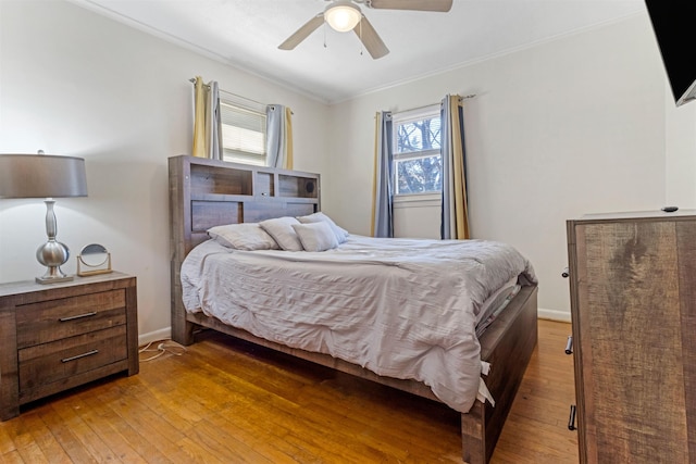 bedroom with ornamental molding, baseboards, ceiling fan, and light wood finished floors