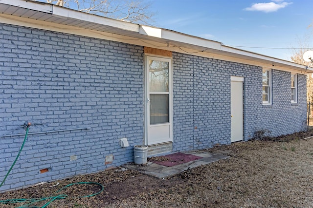 rear view of house with crawl space and brick siding