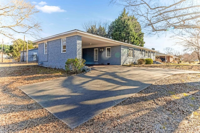 view of front of property featuring a carport, crawl space, concrete driveway, and brick siding