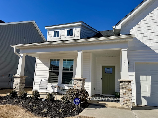 property entrance featuring a porch and an attached garage