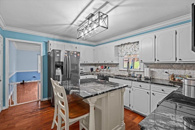 kitchen featuring crown molding, dark wood finished floors, tasteful backsplash, white cabinets, and a sink