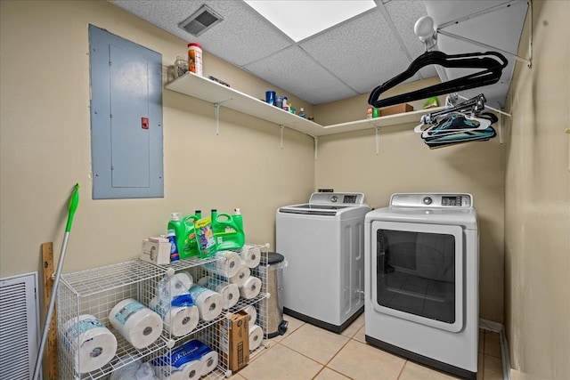 clothes washing area with light tile patterned floors, laundry area, visible vents, electric panel, and washing machine and clothes dryer