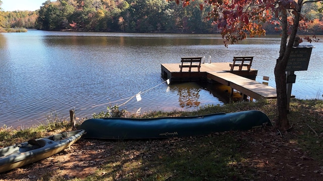 dock area featuring a water view and a wooded view