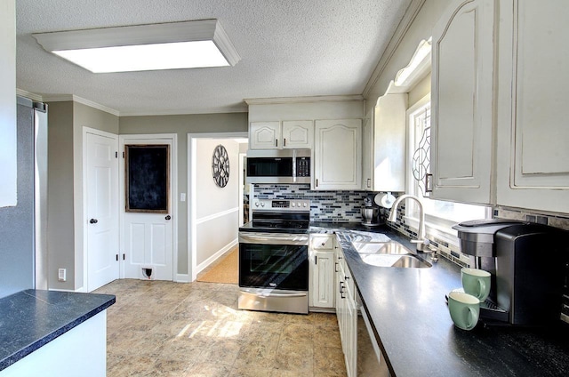 kitchen featuring dark countertops, ornamental molding, a sink, stainless steel appliances, and backsplash