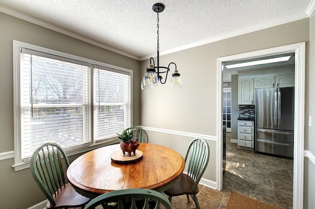 dining area featuring a notable chandelier, a textured ceiling, baseboards, and crown molding