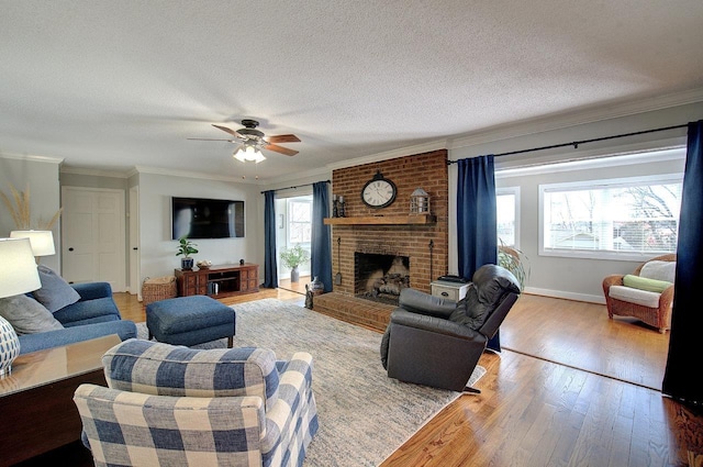 living area with a brick fireplace, crown molding, a textured ceiling, and hardwood / wood-style flooring