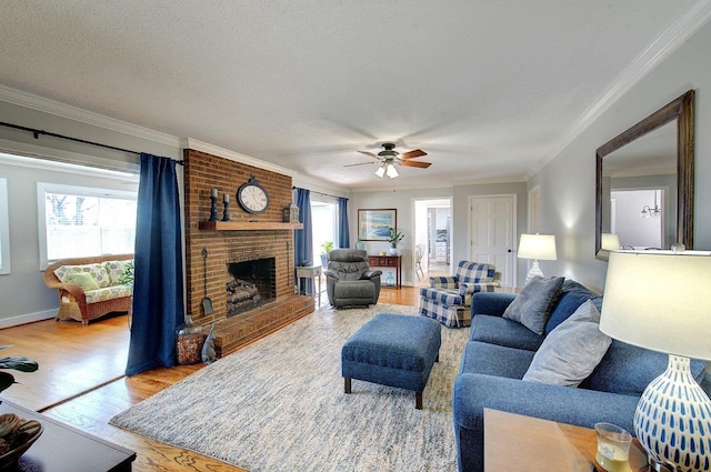 living room with baseboards, light wood-style flooring, ornamental molding, a textured ceiling, and a fireplace