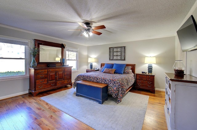 bedroom featuring light wood-style floors, multiple windows, and crown molding