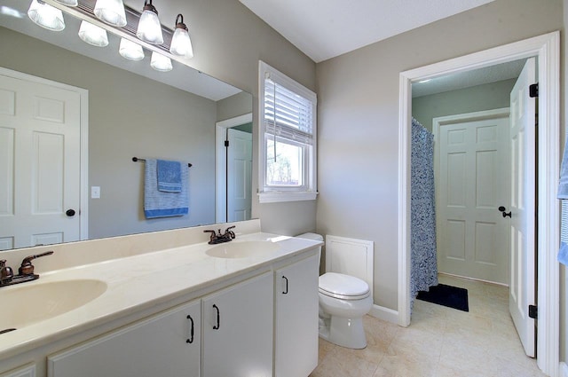 full bath with double vanity, tile patterned flooring, a sink, and toilet