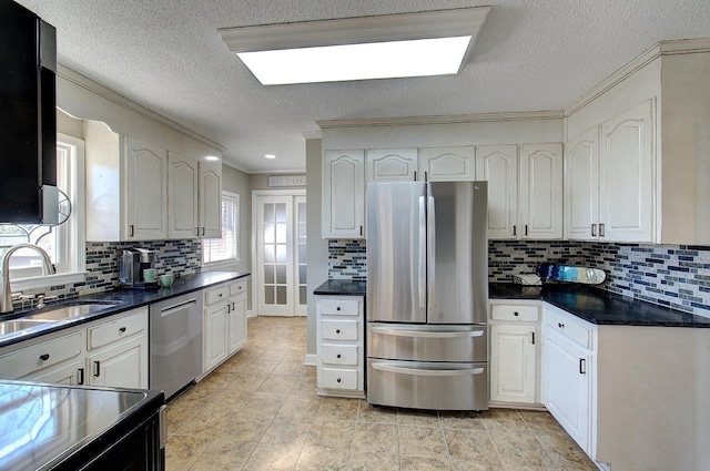 kitchen featuring stainless steel appliances, dark countertops, a sink, and decorative backsplash