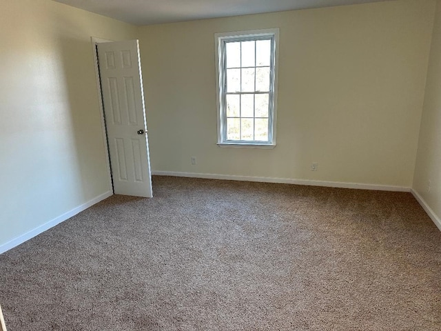 carpeted empty room with baseboards